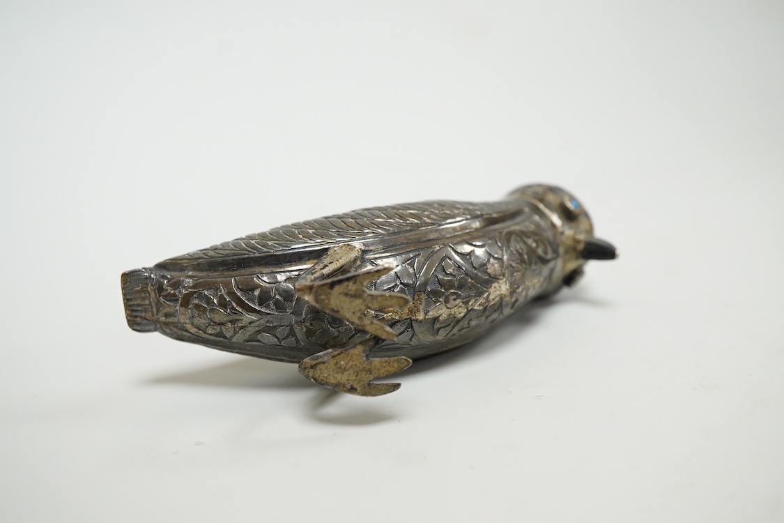 A novelty white metal pepperette, modelled as a free standing bird, with blue glass eyes, indistinct mark to one leg, height 87mm.